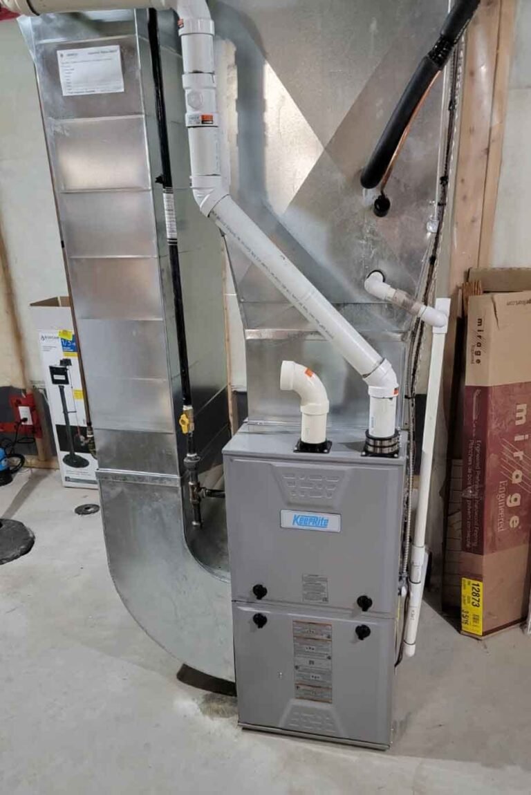High-efficiency gas furnace with new white venting and galvanized ductwork installed in a Niagara basement