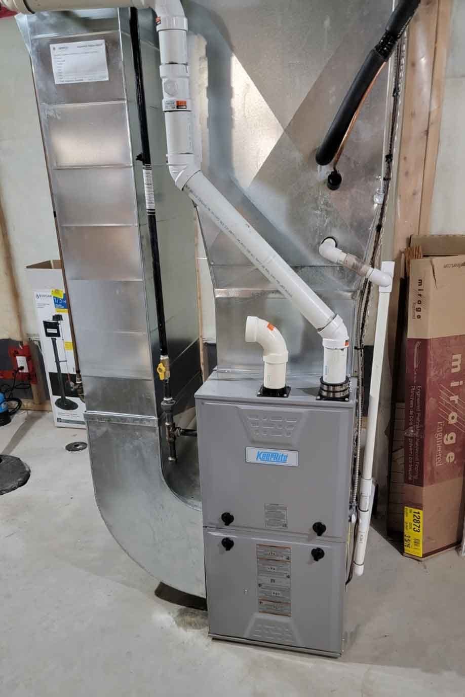 High-efficiency gas furnace with new white venting and galvanized ductwork installed in a Niagara basement