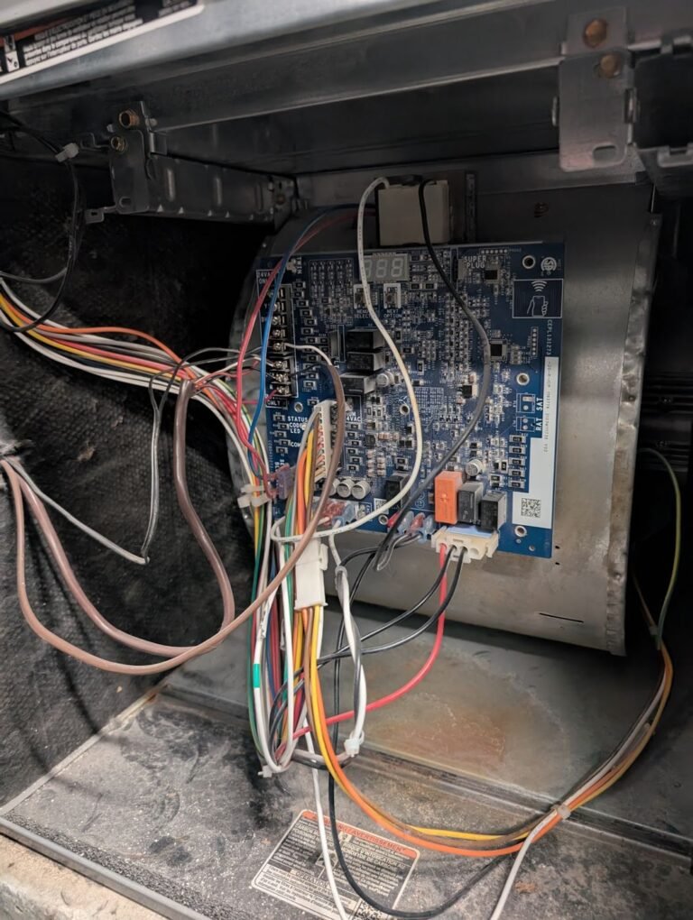 Furnace circuit board with colourful wiring harness and relays inside the blower compartment during troubleshooting