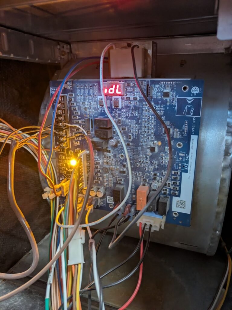 Furnace control board showing an idle status code on its red display with a wiring harness exposed inside the cabinet