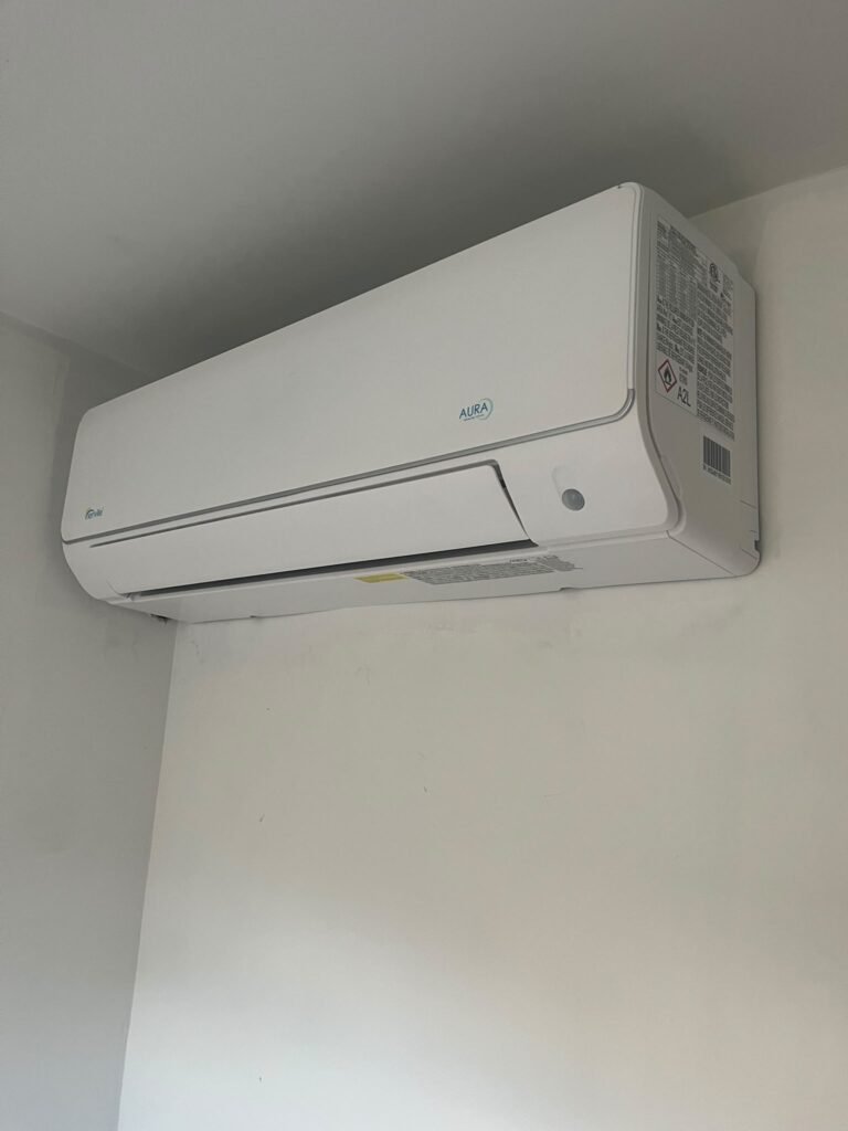 White Senville AURA wall-mounted mini split indoor head high on a white wall