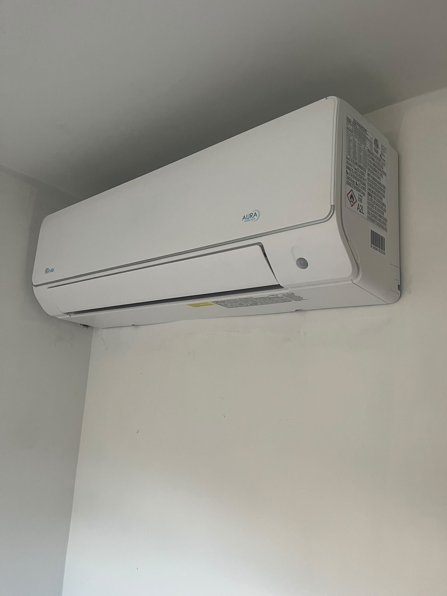 White Senville AURA wall-mounted mini split indoor head high on a white wall