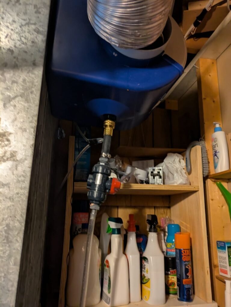 Whole-home humidifier mounted on a furnace duct with a flexible bypass duct, blue housing and water line